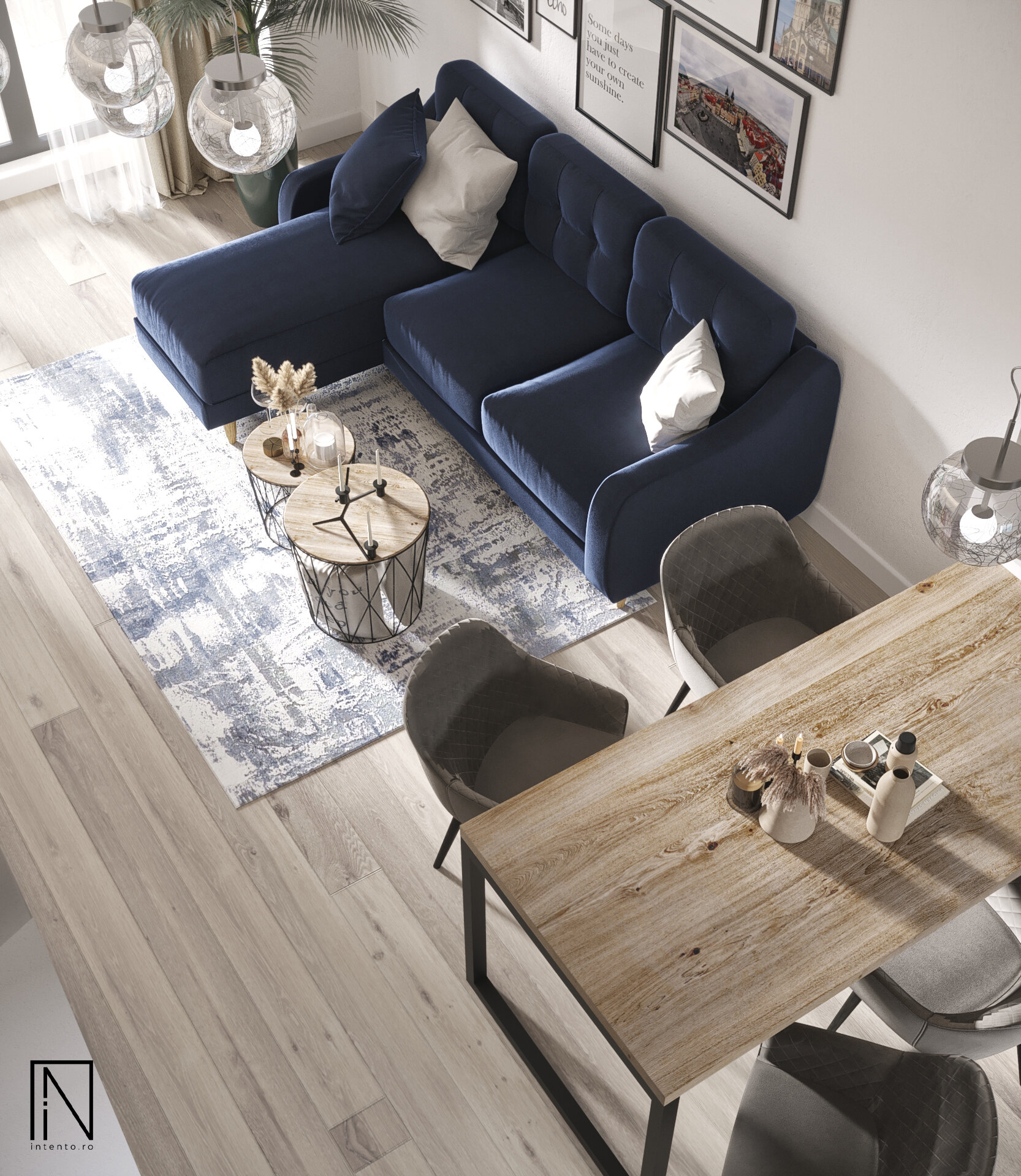 Vedere de sus a unui living cu zonă de dining: canapea din catifea bleumarin, două măsuțe rotunde din lemn, covor alb cu albastru și masă din lemn cu scaune gri