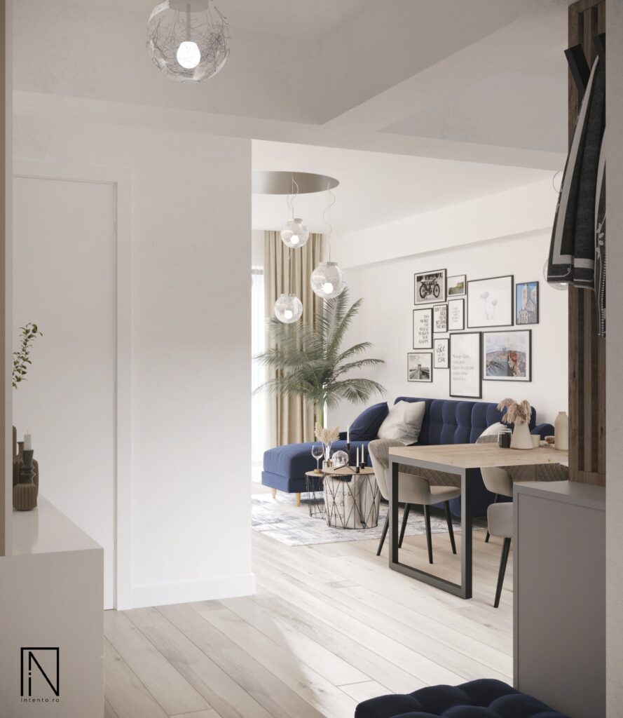 Vedere de la intrare spre zona de zi deschisă, cu canapea albastru-cobalt, palmier, perete cu tablouri și masa de dining