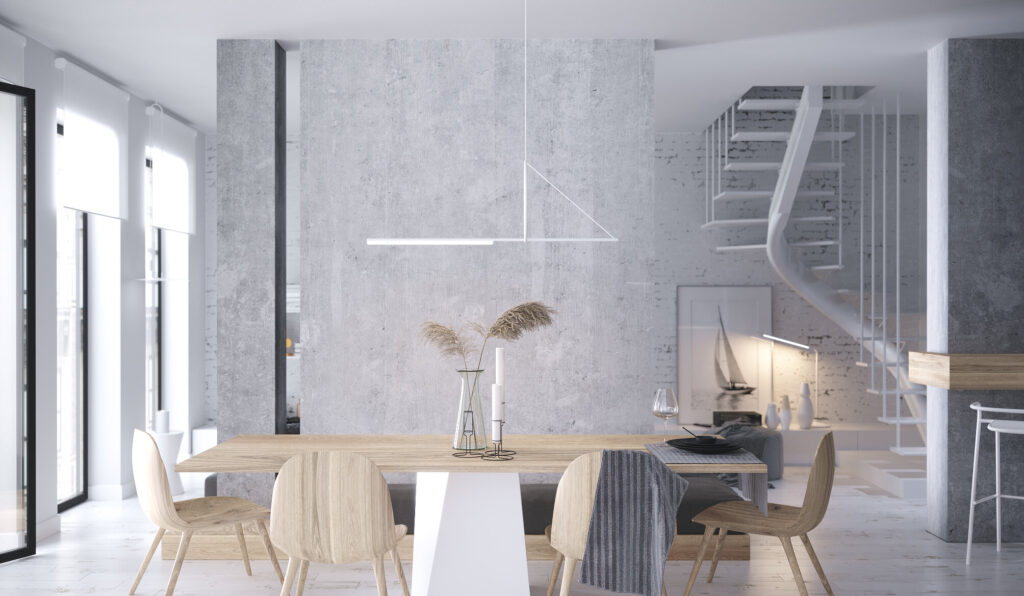 Masă de dining din stejar sub o lustră albă minimalistă, perete din beton aparent și o scară albă în spirală spre etaj
