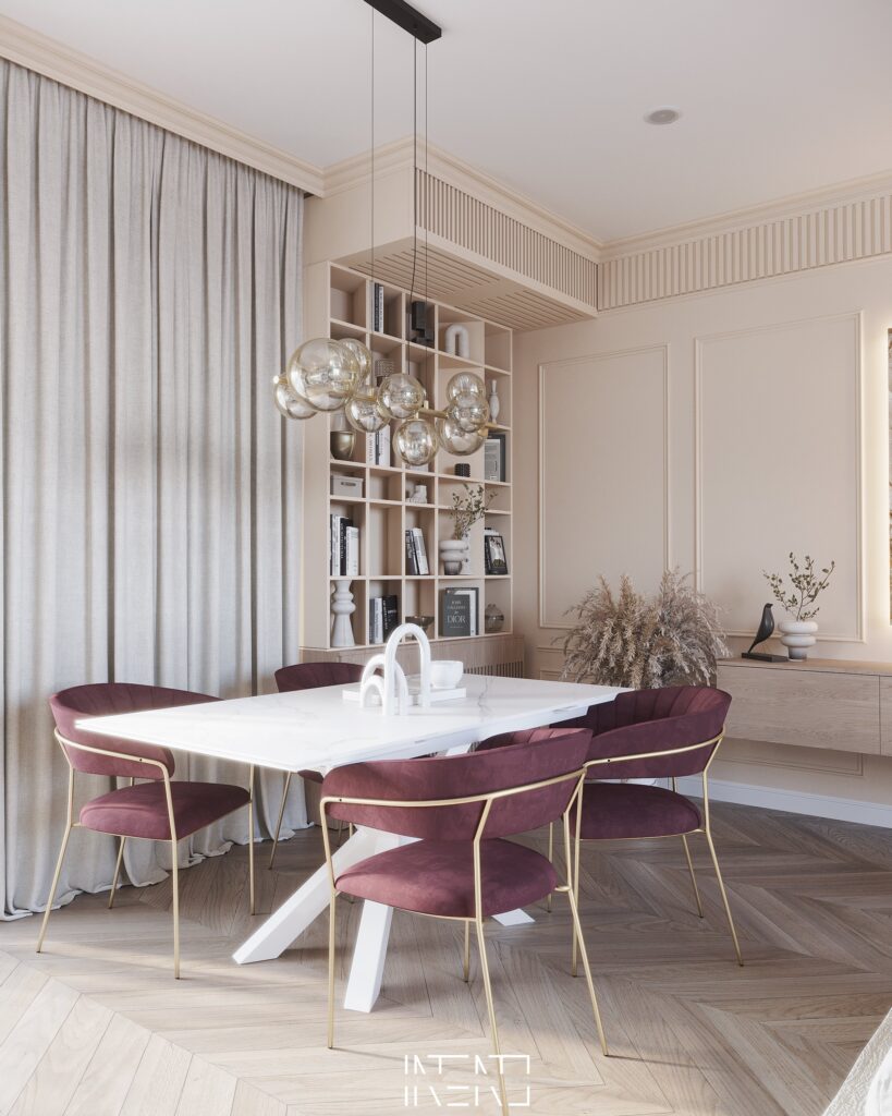 Zonă de dining cu masă albă, scaune din catifea bordo cu picioare aurii, lustră cu globuri de sticlă și bibliotecă încastrată