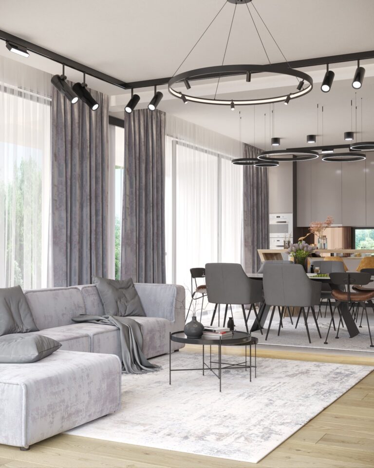 Randare a zonei de zi și de dining deschise, cu canapea gri modulară, lustre-inel și bucătăria în fundal