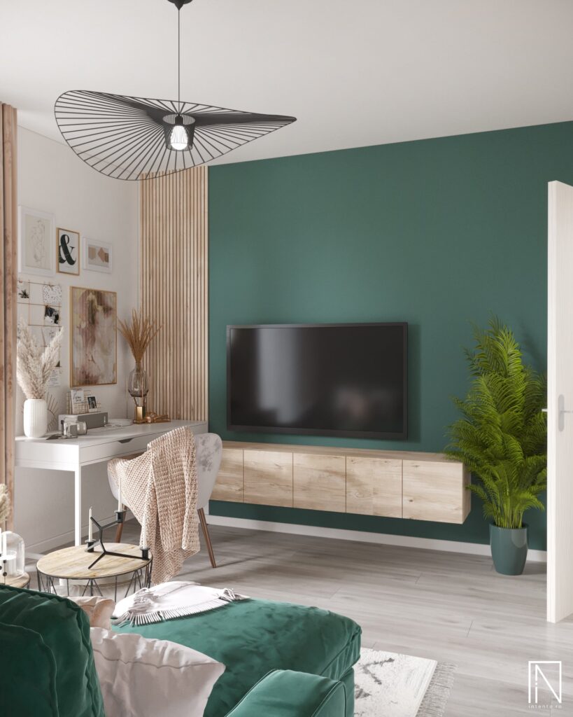 Living cu perete de accent verde închis, TV pe perete deasupra unei comode suspendate din stejar, birou alb lângă lamele de stejar și lustră neagră